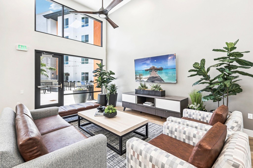 A living room with a brown leather couch, a white couch, a wooden coffee table, and a large painting on the wall.