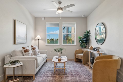A living room with a white couch, a coffee table, a chair, and a painting on the wall.