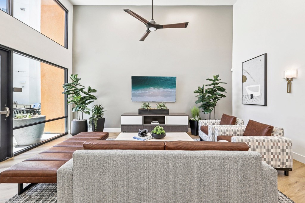 A living room with a grey sofa and a painting on the wall.