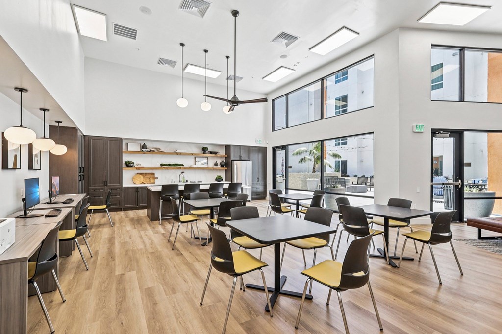 A modern office space with wooden floors and a variety of chairs and tables.