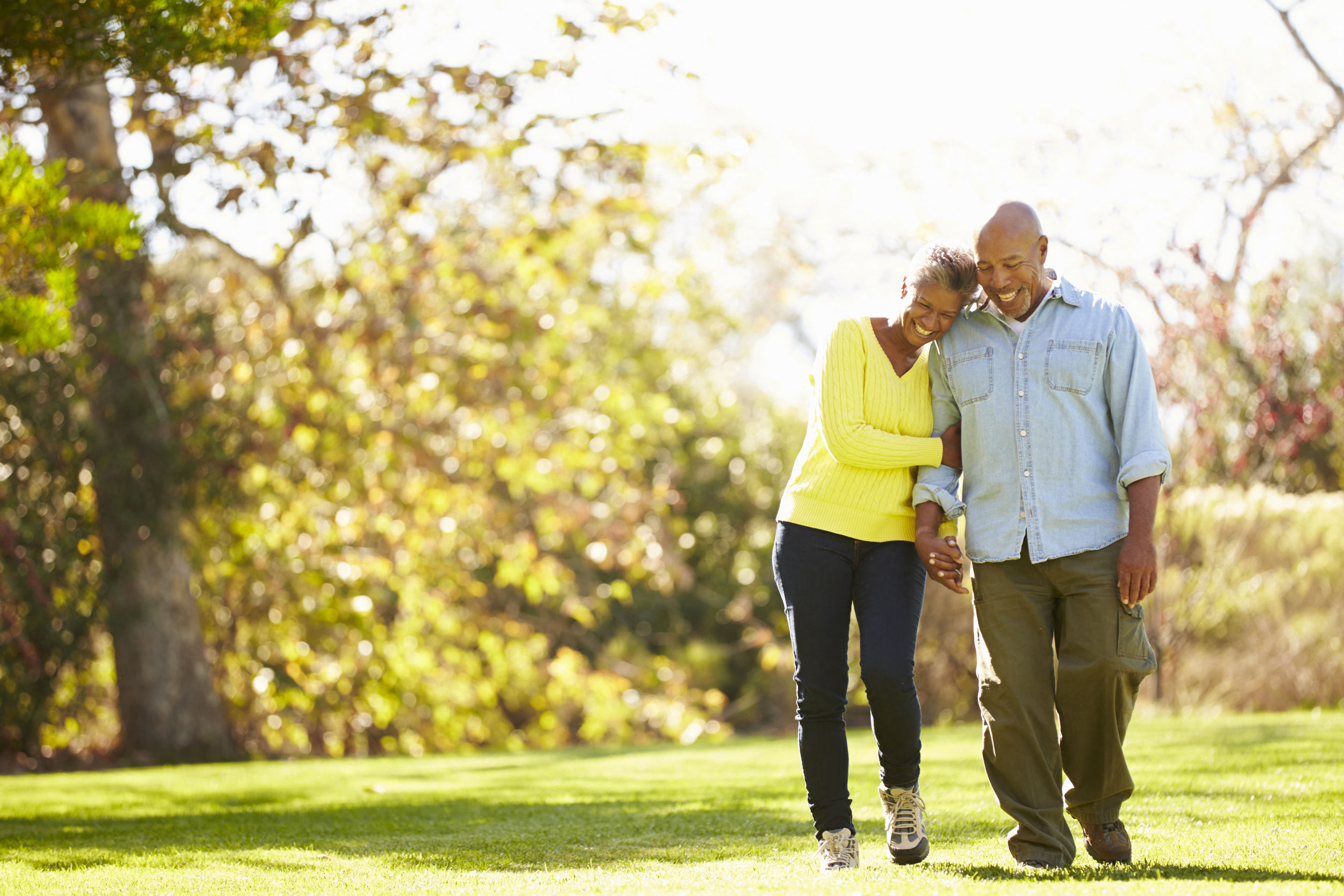 A couple walking hand in hand in a park.