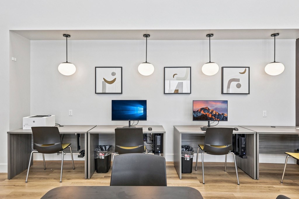 A modern office with a desk, chairs, and a computer monitor.