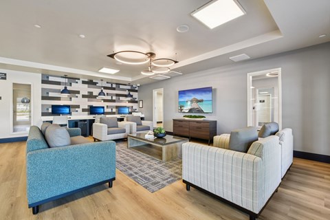 A modern living room with a blue sofa and a painting on the wall.
