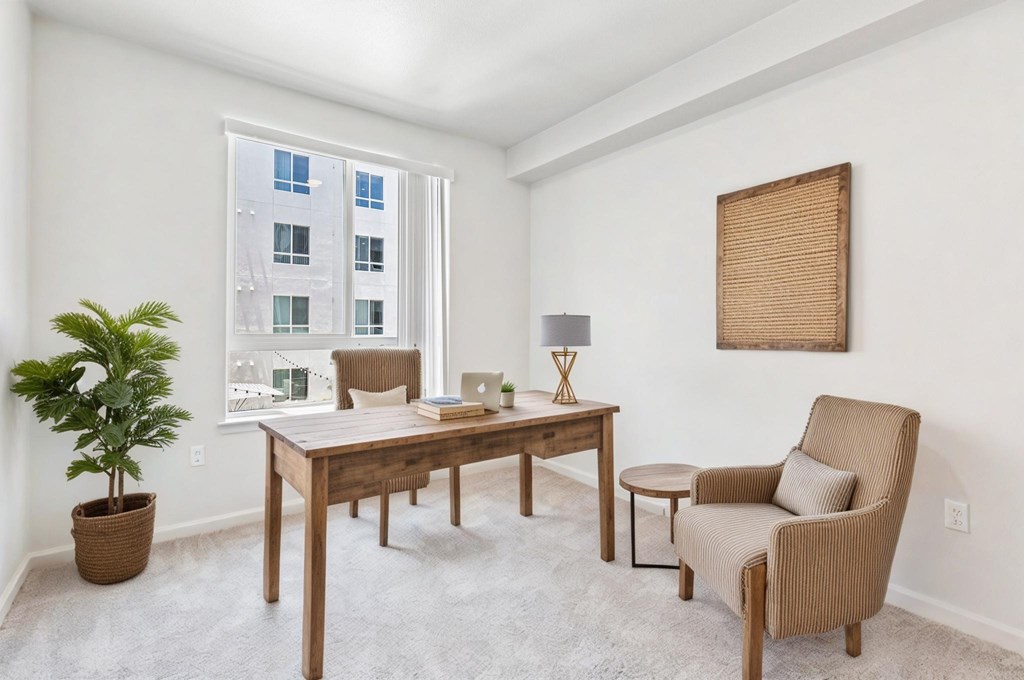 A room with a chair, table, and a potted plant.