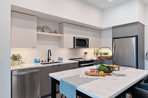 A modern kitchen with a dining table set for two.