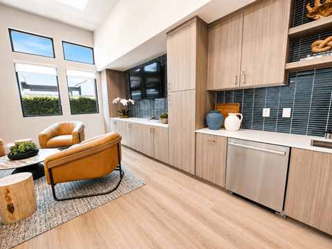 A kitchen with a yellow chair and wooden cabinets.