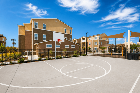 Basketball court with fenced perimeter and shade structures at Terracina at Lancaster | Affordable Apartments, California