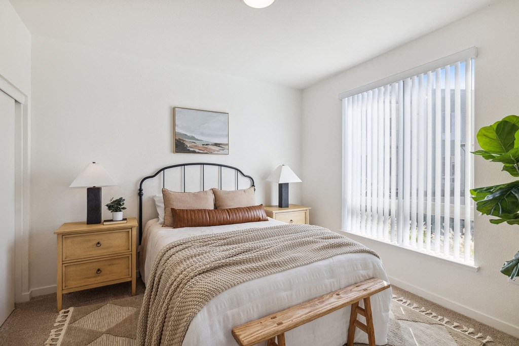 a bedroom with a bed and a large window