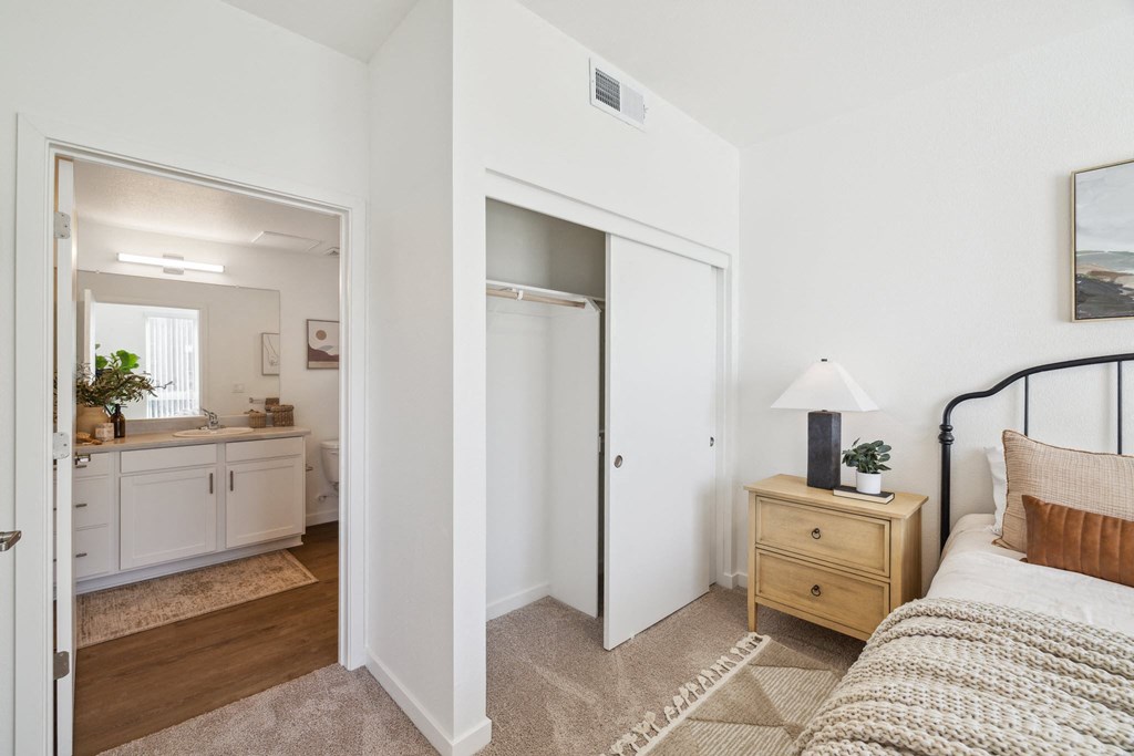 a bedroom with a bed and a bathroom with a mirror