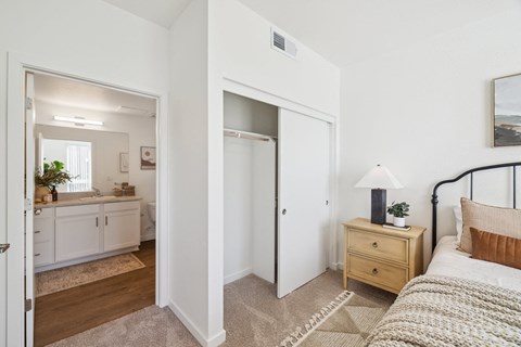 a bedroom with a bed and a bathroom with a mirror