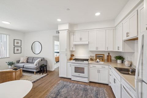 A modern kitchen with white cabinets and appliances.