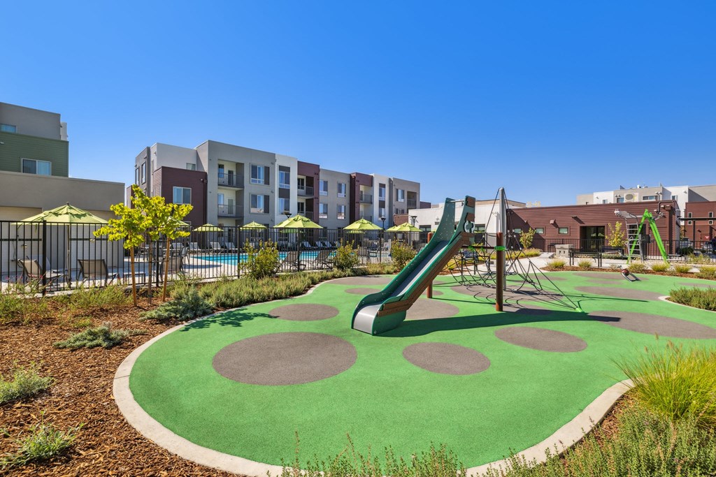 a playground with a slide at an apartment complex