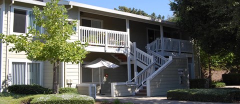 A two-story building with a balcony and stairs leading to the second floor.