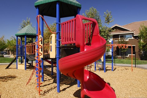 A red slide on a playground.