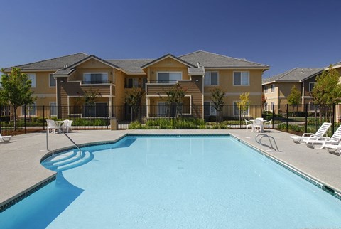 A swimming pool in front of a row of houses.