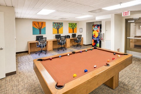 A pool table in a room with a painting on the wall.