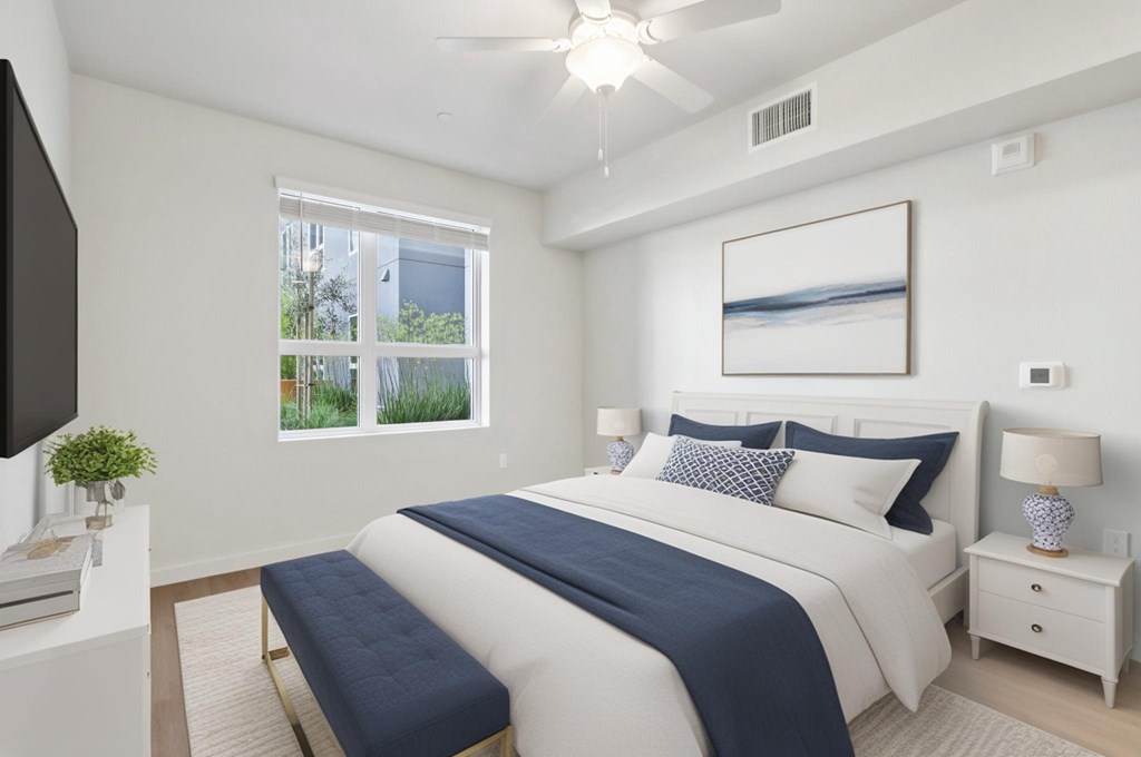 A bedroom with a large bed and a television on a stand.