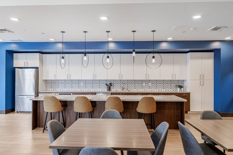 A modern kitchen with a long table and chairs.