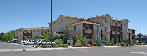 Apartment complex with a parking lot in front.