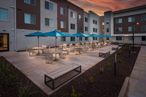 a courtyard with tables and chairs and umbrellas