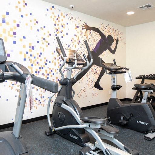 a gym with a wall mural of a man running on a treadmill