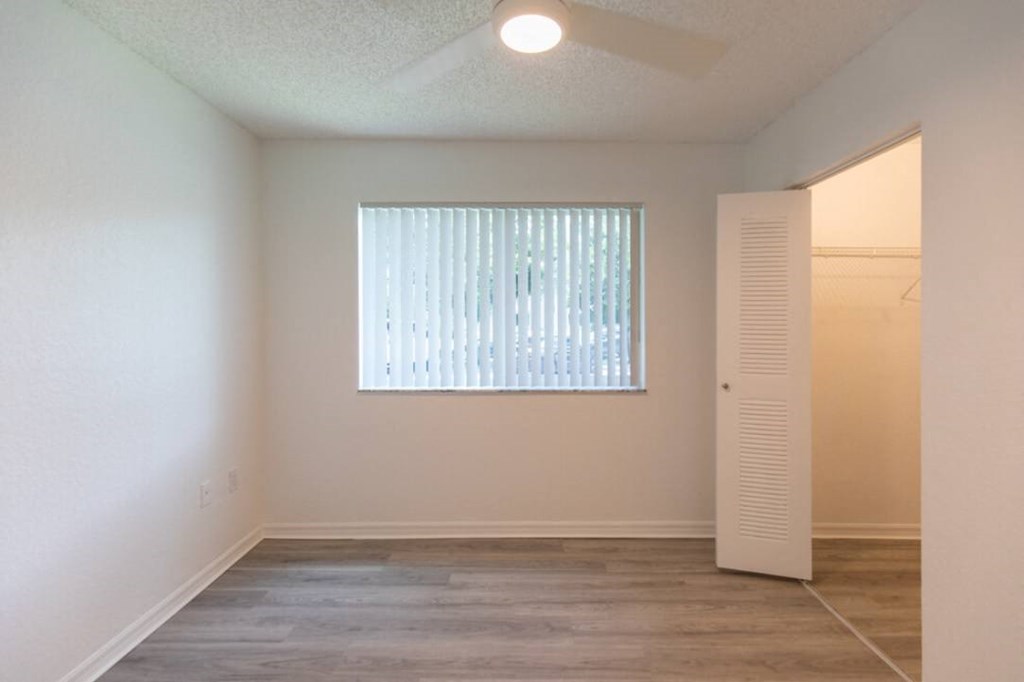an empty room with a large window and white walls