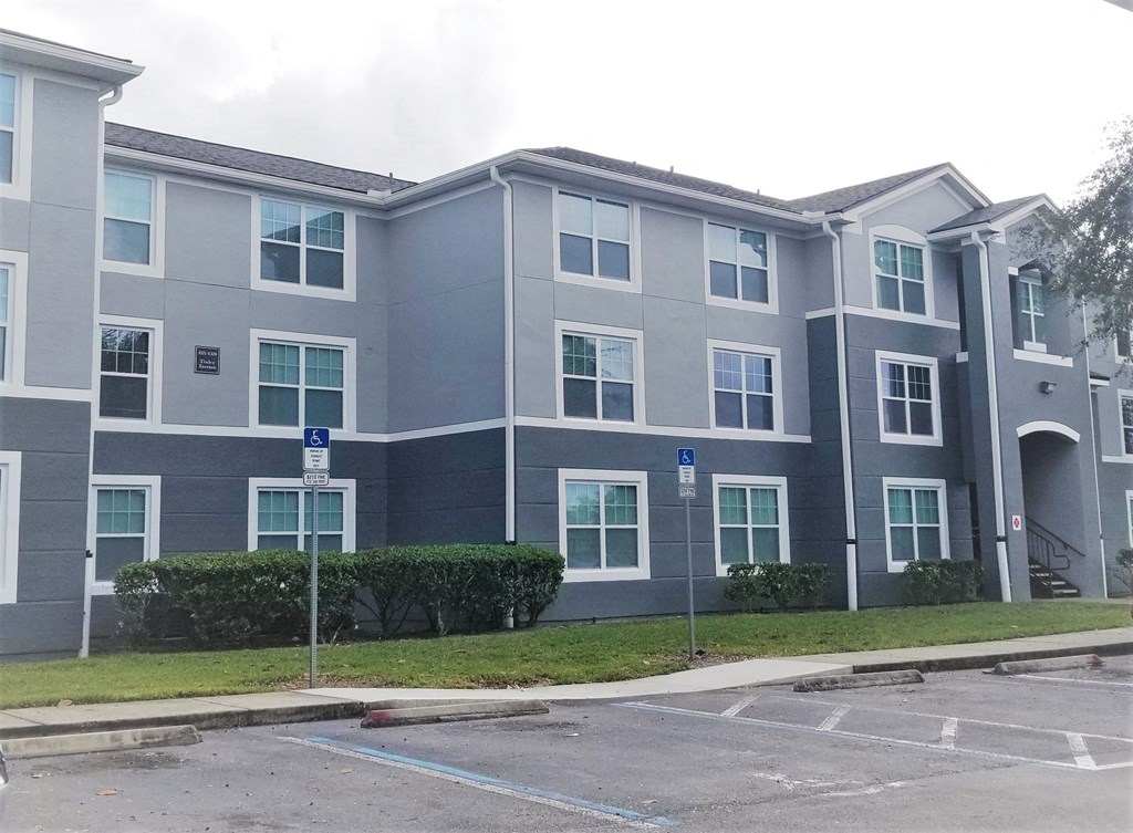 an apartment building with a parking lot in front of it