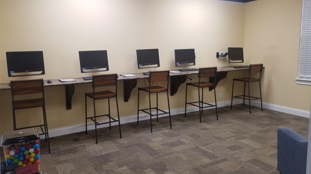 a row of computer monitors on desks in a room
