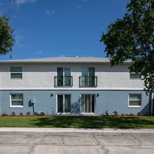 a blue and white building with a lawn in front of it