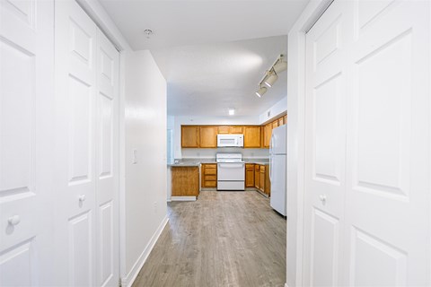 an empty kitchen with wooden cabinets and white appliances