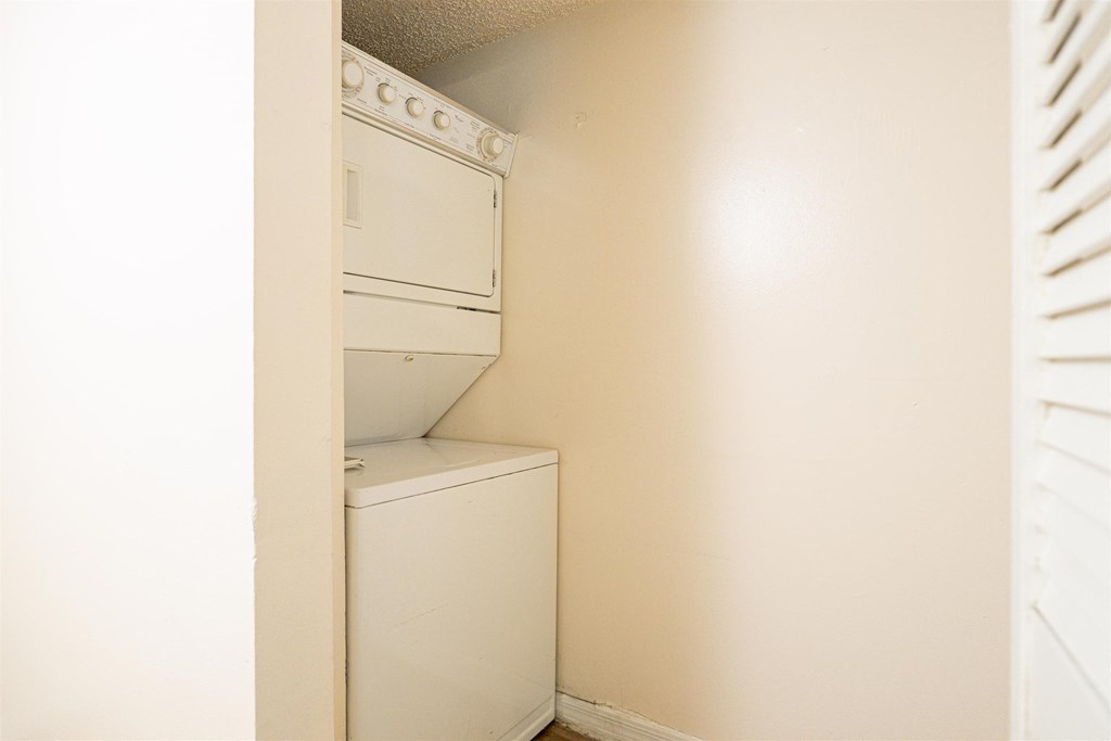 an empty laundry room with a washer and dryer in it