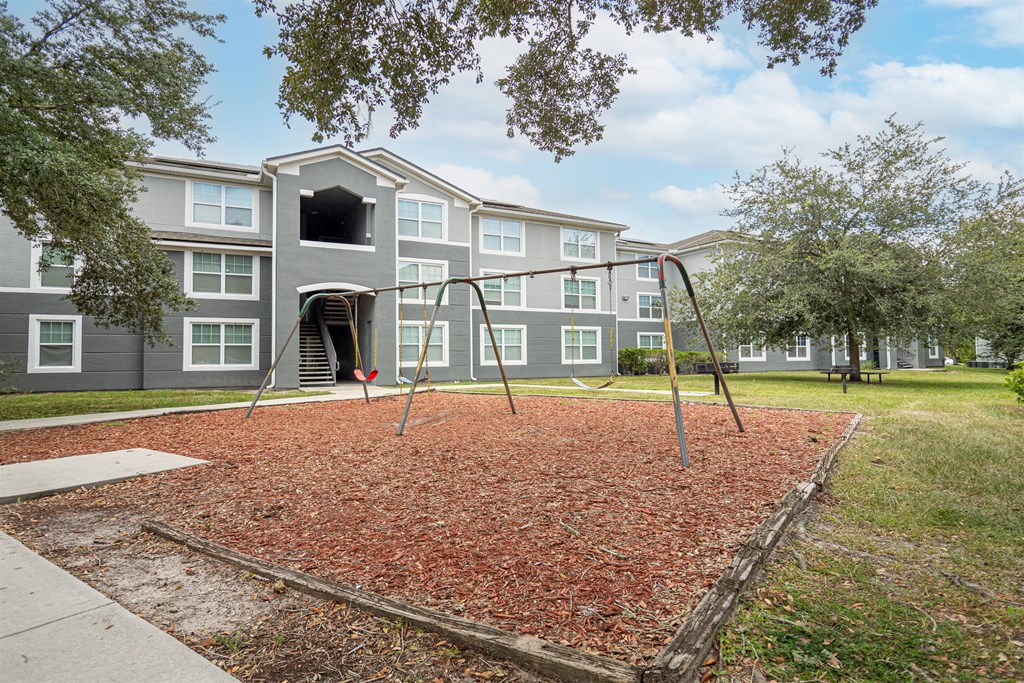 a swing set in front of an apartment building