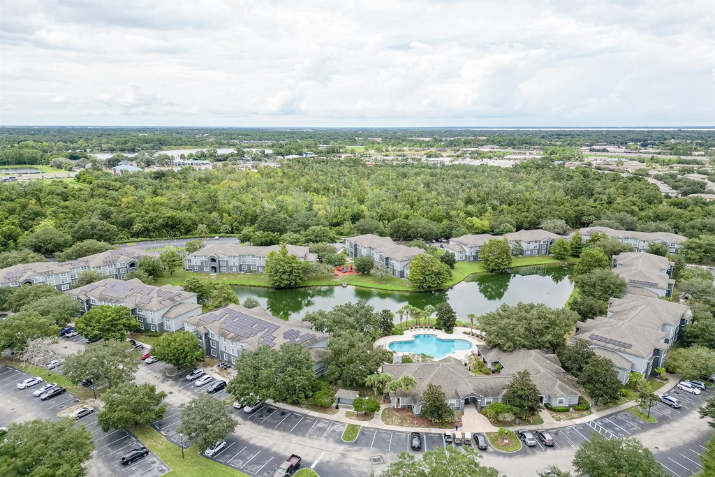 an aerial view of a neighborhood with a pool and trees