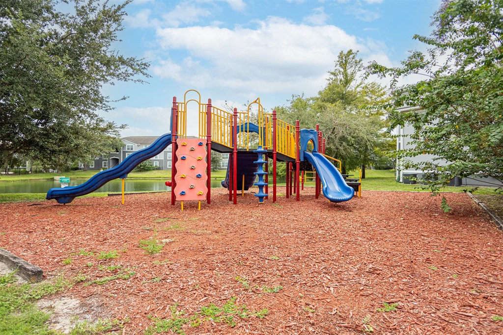a playground with a swing set and slides in a park