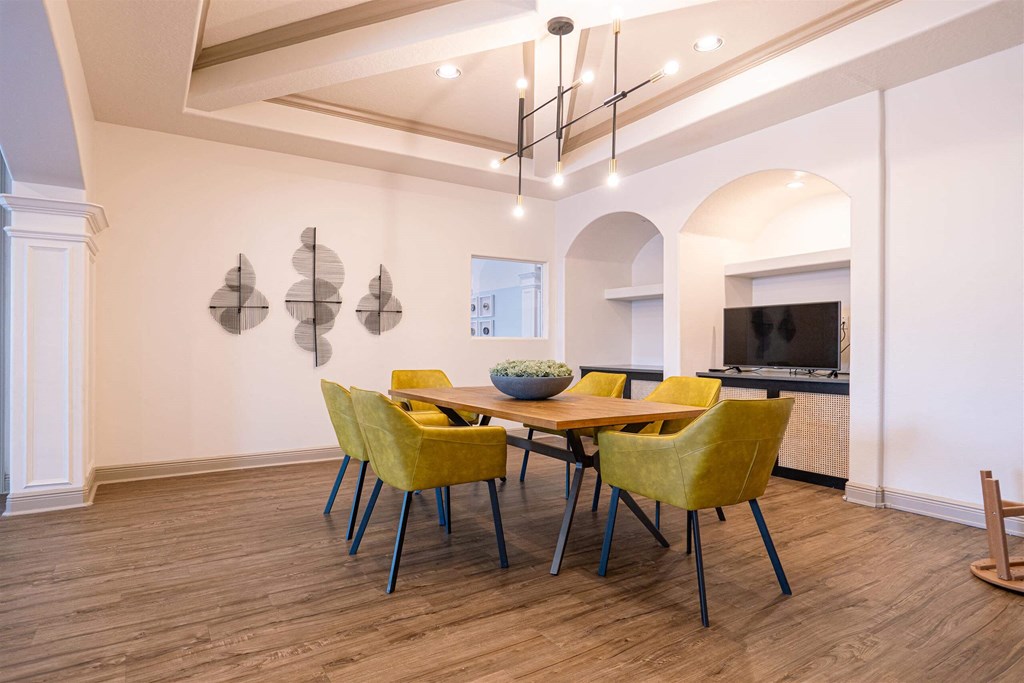 a dining room with yellow chairs and a wooden table