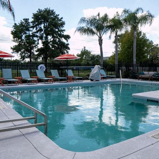 a large swimming pool with chairs and umbrellas