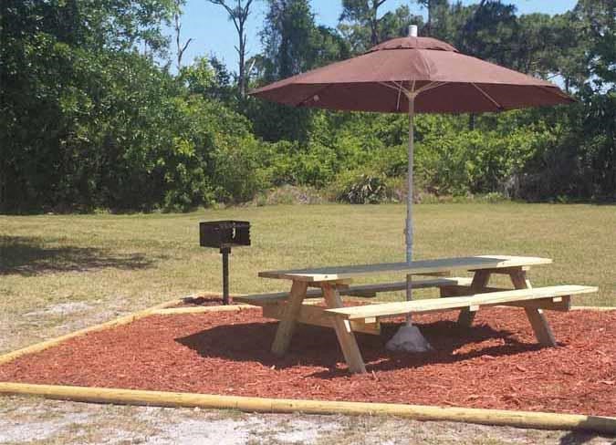 a picnic table with an umbrella in a park