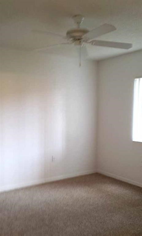 an empty room with a ceiling fan in it