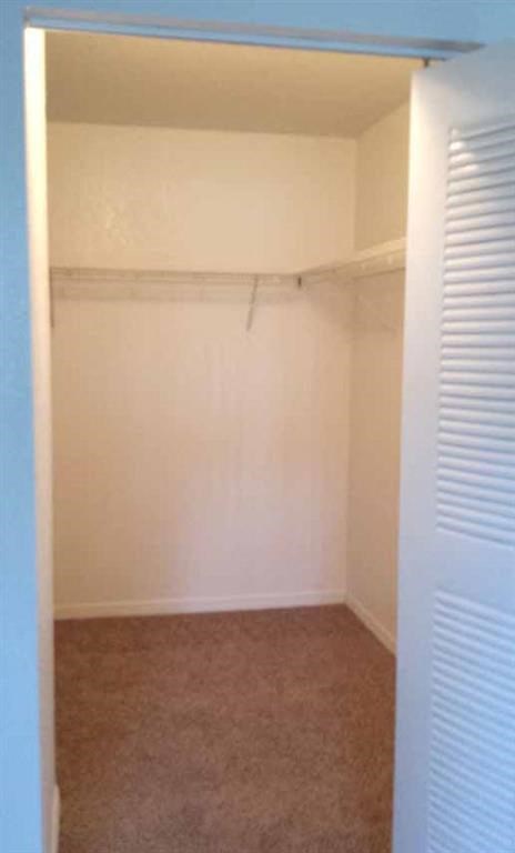 an empty room with a white wall and a closet