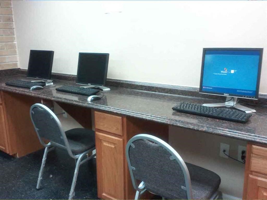 a desk with two computer monitors and two chairs