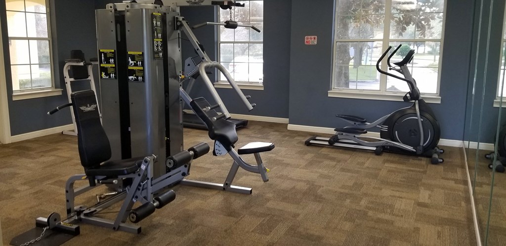 a home gym with exercise machines and a large window