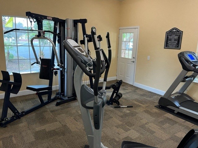 the fitness room has cardio equipment and a large window