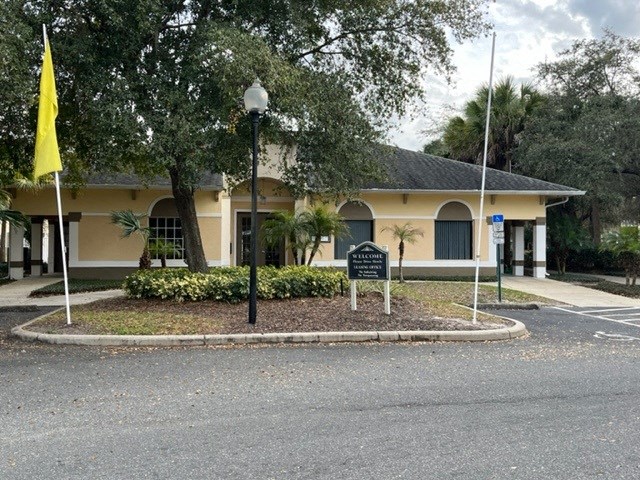 a yellow building with a black sign in front of it