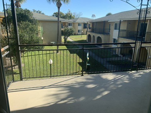 the view from our balcony of our yard and our apartment buildings