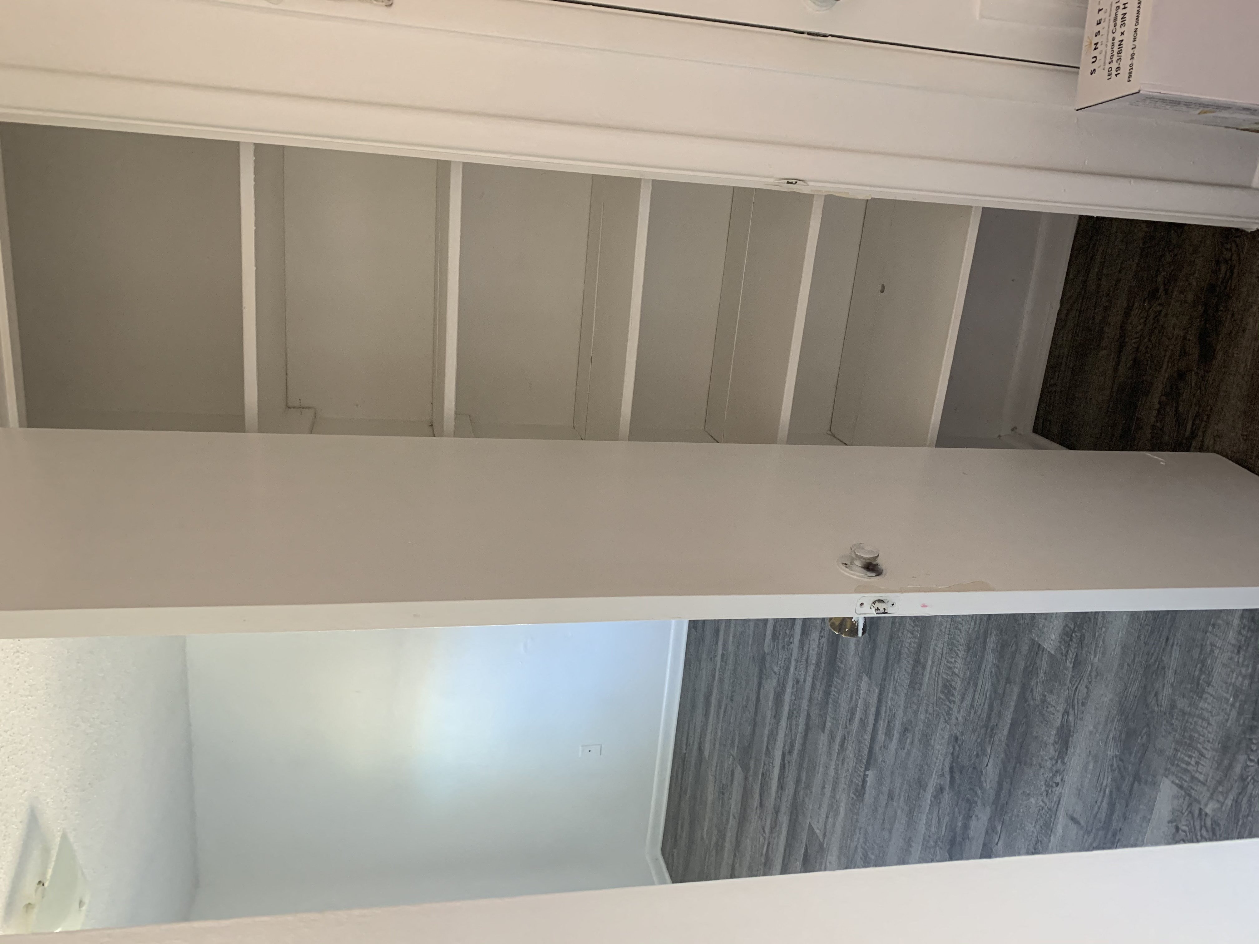 a kitchen with a white counter top and a cabinet