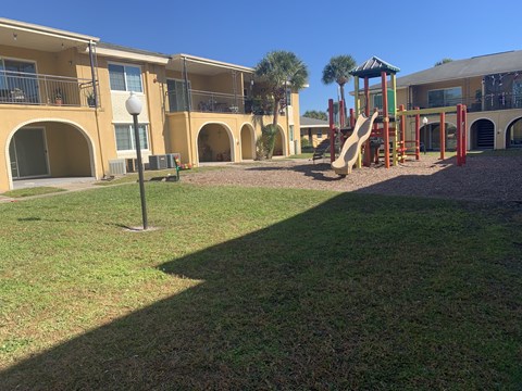 a playground with a slide in front of a building