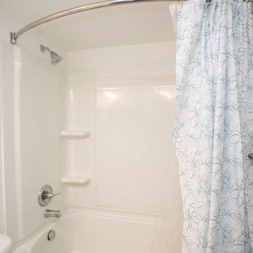 a white bathroom with a shower curtain and a white tub