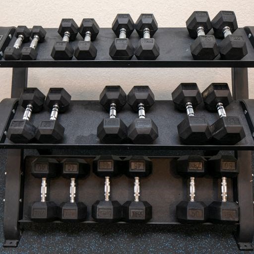a rack of dumbbells and weights on the floor