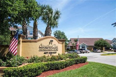 the sign for stratford park apartments flags