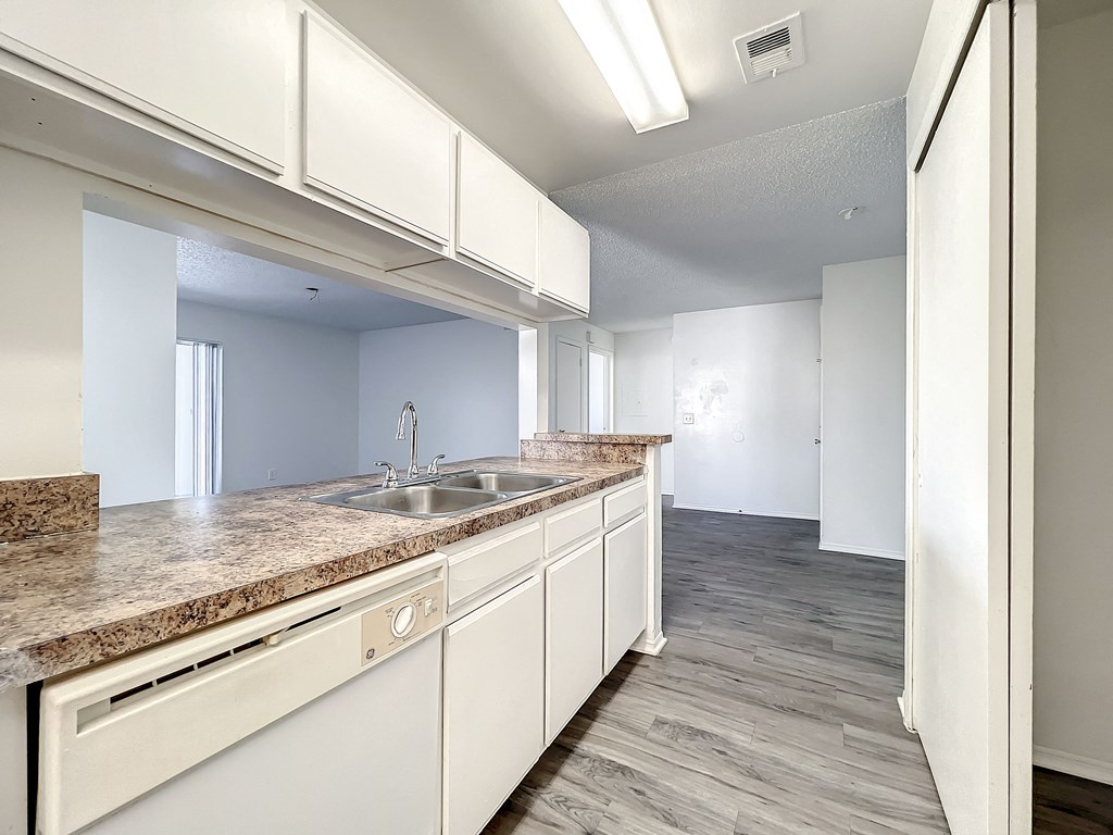 a kitchen with granite countertops and white cabinetry